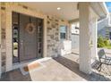 Inviting front entrance featuring a gray front door with glass sidelights, stone facade, and a welcoming wreath at 10626 Bonne Chance Dr, Orlando, FL 32832