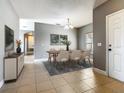Elegant dining room featuring stylish modern furnishings, neutral tones, and sleek tile flooring at 107 Carlisle Ct, Kissimmee, FL 34758