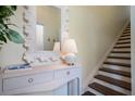 Light and bright foyer area with elegant console table and decorative mirror near the stairs at 112 Southern Pecan Cir # 201, Winter Garden, FL 34787