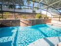 Sparkling pool with water feature, surrounded by screened enclosure and lush landscaping at 1870 Vale Dr, Clermont, FL 34711