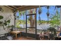 Enjoy a screened porch with views of a lake surrounded by hanging plants and a table at 200 Maitland Ave # 153, Altamonte Springs, FL 32701