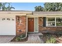 Close-up showcasing the charming brick facade and front door with brick paver walkway and landscaped accents at 2024 Linden Road, Winter Park, FL 32792