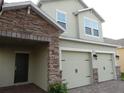 Close up of a two-story home with brick driveway and stone details, two-car garage at 2737 Monticello Way, Kissimmee, FL 34741