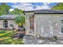 Inviting entrance of the home featuring a solid wood door and manicured landscape at 2810 Windsong Ln, St Cloud, FL 34772