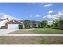 A charming single-story brick home boasts a well-kept lawn, manicured landscaping, and a welcoming entrance at 3306 Fishermans Cv, Winter Park, FL 32792