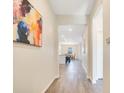 Hallway with wood floors leading to an open-concept living area with a table and chairs at 3761 Shoveler Ave, Leesburg, FL 34748
