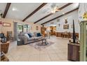 Spacious living room featuring tile floors, beamed ceilings, and seamless transition to the dining area at 3790 Ne 22Nd Ave, Ocala, FL 34479