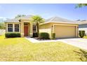 Charming single-story home featuring a well-kept lawn, mature landscaping, and an attached two-car garage at 3812 Creswick Cir, Orlando, FL 32829