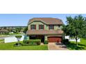 Charming two-story home featuring manicured landscaping, a brick driveway, and a two-car garage at 4113 Longbow Dr, Clermont, FL 34711