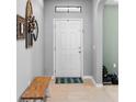 Bright foyer with neutral paint, tile flooring, a bench, and decorative accents creating a welcoming entrance at 4113 Longbow Dr, Clermont, FL 34711
