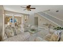 Bright living room features neutral-toned decor, tiled floors, staircase, and an archway leading to the dining room at 4574 Ficus Tree Rd, Kissimmee, FL 34758