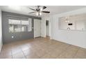 Bright living room with neutral tile flooring, a ceiling fan and a view to the dining area at 4584 Pheasant Run Dr # B, Orlando, FL 32808