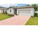 Inviting single-story home with a brick driveway and attached two-car garage at 4713 Jasmine Cir, Leesburg, FL 34748