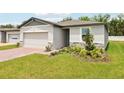 Single-story home with a brick driveway, attached garage and inviting curb appeal at 4717 Jasmine Cir, Leesburg, FL 34748