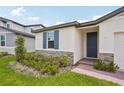 Charming home exterior with blue door and shutters, stone accents, and well-maintained landscaping at 4728 Jasmine Cir, Leesburg, FL 34748