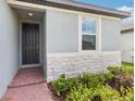 A close up of the front door of the house with stone accents and manicured landscaping at 4732 Jasmine Cir, Leesburg, FL 34748