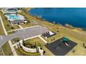 Aerial view of community amenities featuring a playground, community pool, and scenic lake at 4981 Kaia Ave, Winter Haven, FL 33884