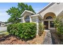 Close-up of a charming front door framed by lush landscaping and a welcoming walkway at 5537 Misty Woods Dr, Oviedo, FL 32765