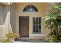 Inviting front entrance featuring a classic door, window, and lush greenery for added privacy at 5537 Misty Woods Dr, Oviedo, FL 32765
