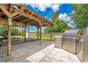A large outdoor grill is next to an outdoor living space that is covered and has a wood deck at 6426 Sw 60 Ave, Ocala, FL 34474