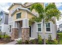Beautiful two-story home featuring a lovely landscaped yard with a young palm tree at 6442 Pine Warbler Way, St Cloud, FL 34771