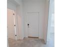 Clean, white hallway featuring a doorway and closet providing access to various rooms at 6442 Pine Warbler Way, St Cloud, FL 34771