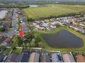 An aerial view showcasing the home's location, surrounded by other houses and a pond at 655 Eagle Pointe South, Kissimmee, FL 34746