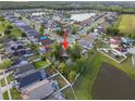 Aerial view of the neighborhood showing the home, surrounding houses, and nearby pond at 655 Eagle Pointe South, Kissimmee, FL 34746