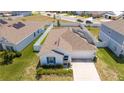 Aerial view of the home with a well-kept lawn, solar panels and two car garage at 6935 Dilly Lake Ave, Groveland, FL 34736