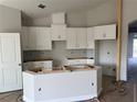 Bright kitchen featuring white cabinetry, an island, and modern design elements at 738 Pointe Emerson Blvd, Apopka, FL 32703