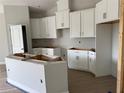 Bright kitchen featuring white cabinets and a large island ready to be fitted with appliances at 738 Pointe Emerson Blvd, Apopka, FL 32703