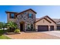 Beautiful two-story home with stone accents, a tile roof, and a three-car garage at 8625 Brixford St, Orlando, FL 32836