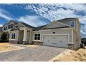 Charming two-story home with a two-car garage, beautiful stone accents, and brick paver driveway at 873 Pointe Emerson Blvd, Apopka, FL 32703