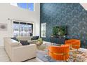 Bright living room with high ceilings, modern furniture, and a sliding glass door to the backyard at 9179 Sommerset Hills Dr, Davenport, FL 33896
