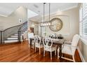 Formal dining room featuring hardwood floors, elegant chandelier, wainscoting, and a staircase in the background at 9684 Sweetleaf St, Orlando, FL 32827