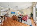 Spacious living room with hardwood floors, ceiling fan, neutral paint, and bright natural light at 9684 Sweetleaf St, Orlando, FL 32827