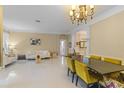 Open-concept dining area featuring sleek tile floors, modern chandelier, and easy access to living spaces at 11025 Ledgement Ln, Windermere, FL 34786