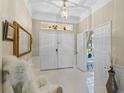 Elegant foyer with bright tile floors, double front doors, and modern light fixtures create a welcoming entry at 11025 Ledgement Ln, Windermere, FL 34786