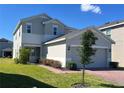 This two-story home offers a well-maintained lawn, brick driveway, and an attached two-car garage at 1116 Myrtle Hammock Ln, Davenport, FL 33837