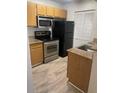 Efficient kitchen with stainless steel appliances, wood cabinets, and light countertops at 11520 Westwood Blvd # 515, Orlando, FL 32821