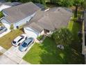 Aerial view of a well-maintained home with a manicured lawn and driveway at 1567 Oak Hill Trl, Kissimmee, FL 34747