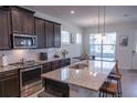 Modern kitchen featuring stainless steel appliances, granite countertops, and an island with seating at 16274 Taliesin St, Winter Garden, FL 34787