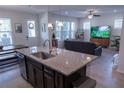 Open-concept kitchen and living area featuring a granite island, stainless sink and modern design at 16274 Taliesin St, Winter Garden, FL 34787