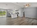 Open-concept kitchen and living space with wood flooring, modern lighting, and island at 17787 Sw 22Nd Ave, Ocala, FL 34473