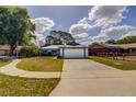 Charming single-story home featuring a two-car garage, blue trim, and well-maintained landscaping at 2729 Hilda Ct, Orlando, FL 32826