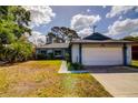 Charming single-story home featuring a two-car garage, blue trim, and well-maintained landscaping at 2729 Hilda Ct, Orlando, FL 32826