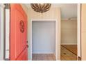 A lovely home entryway features a bright red door, stylish overhead lighting and ceramic tile flooring at 2990 Mallard Dr, Deltona, FL 32738