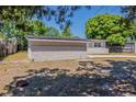 View of the house's back exterior, blending brick and siding, framed by a wooded perimeter at 3718 Mitchell Rd, Orlando, FL 32808