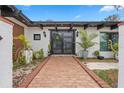 Stylish home entrance featuring double doors, brick walkway, and lush, decorative plants at 409 San Sebastian Prado, Altamonte Springs, FL 32714