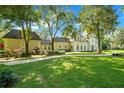 Expansive front lawn showcasing the home's beautiful exterior and mature shade trees at 5100 Cranes Point Ct, Orlando, FL 32839